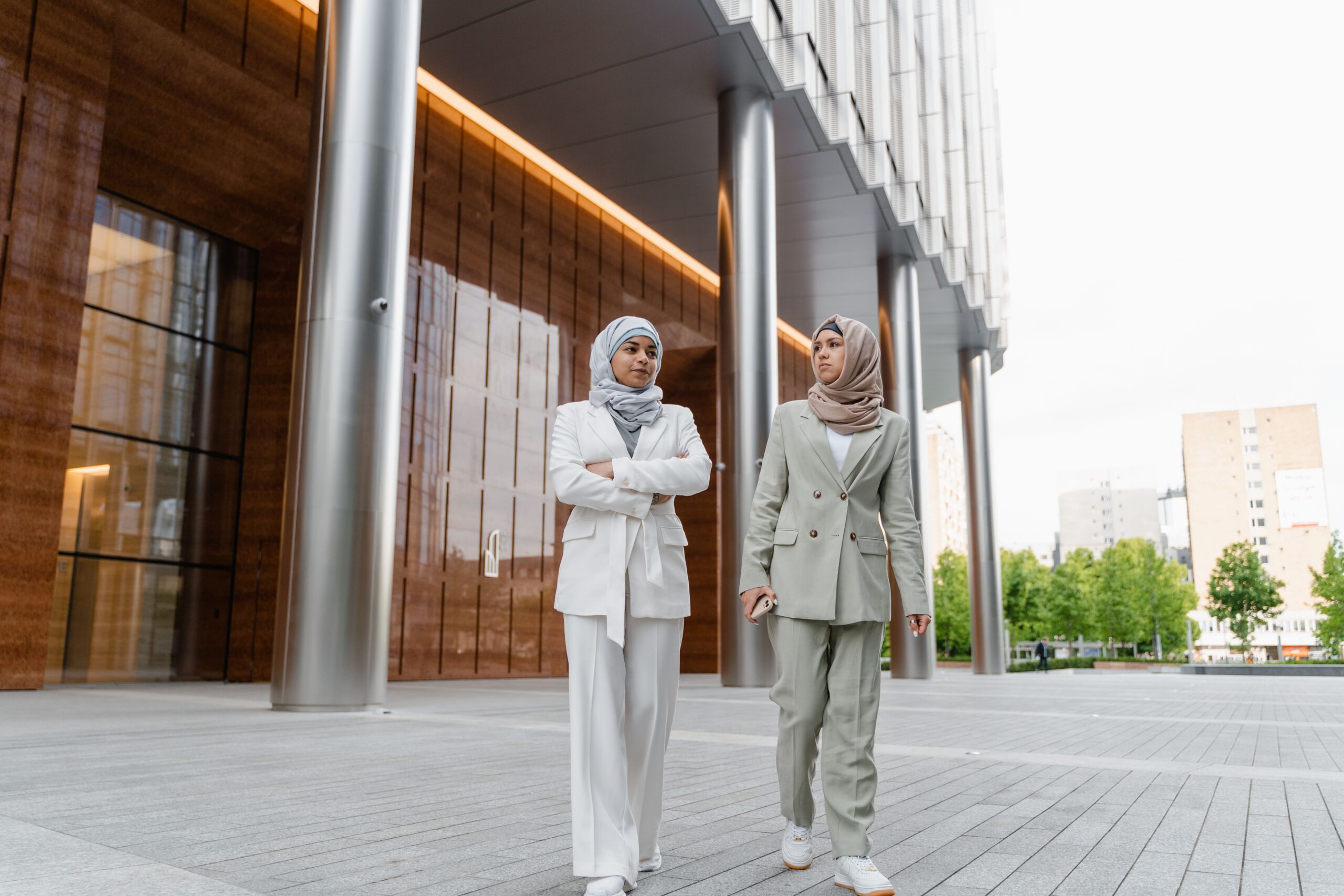 Deux femmes professionnelles en tailleur mastour devant un immeuble moderne