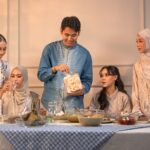 Famille réunie autour d'une table festive pour célébrer l'Aïd en tenues traditionnelles élégantes