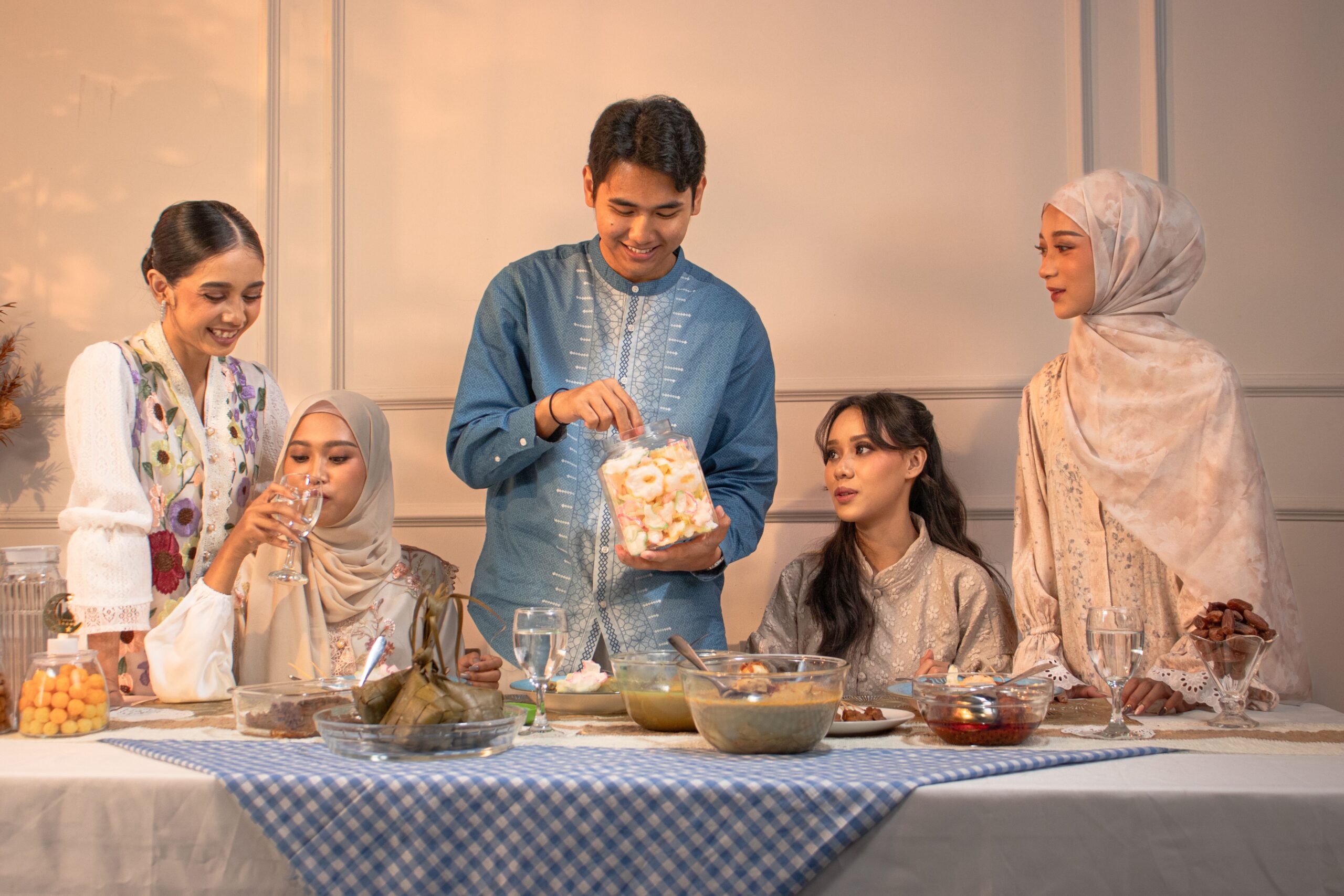 Famille réunie autour d'une table festive pour célébrer l'Aïd en tenues traditionnelles élégantes