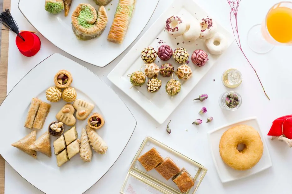 Assortiment de pâtisseries orientales variées présentées sur des assiettes blanches