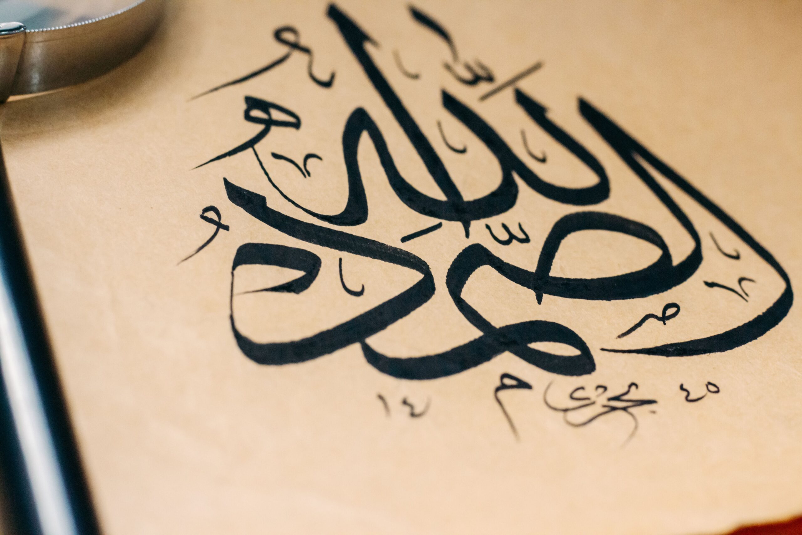 Calligraphie arabe en cours d'écriture sur papier avec annotations