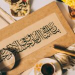 Calligraphie arabe traditionnelle sur papier avec loupe et objets décoratifs