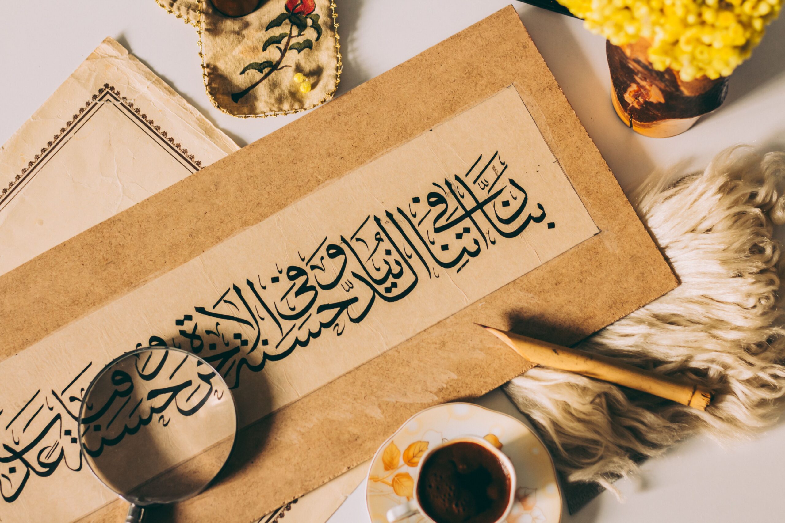 Calligraphie arabe traditionnelle sur papier avec loupe et objets décoratifs