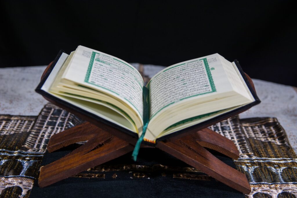 Coran ouvert sur un support en bois montrant la calligraphie arabe traditionnelle