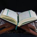 Coran ouvert sur un support en bois montrant la calligraphie arabe