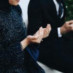 Couple musulman en tenue formale les mains levées en prière lors de la cérémonie de mariage