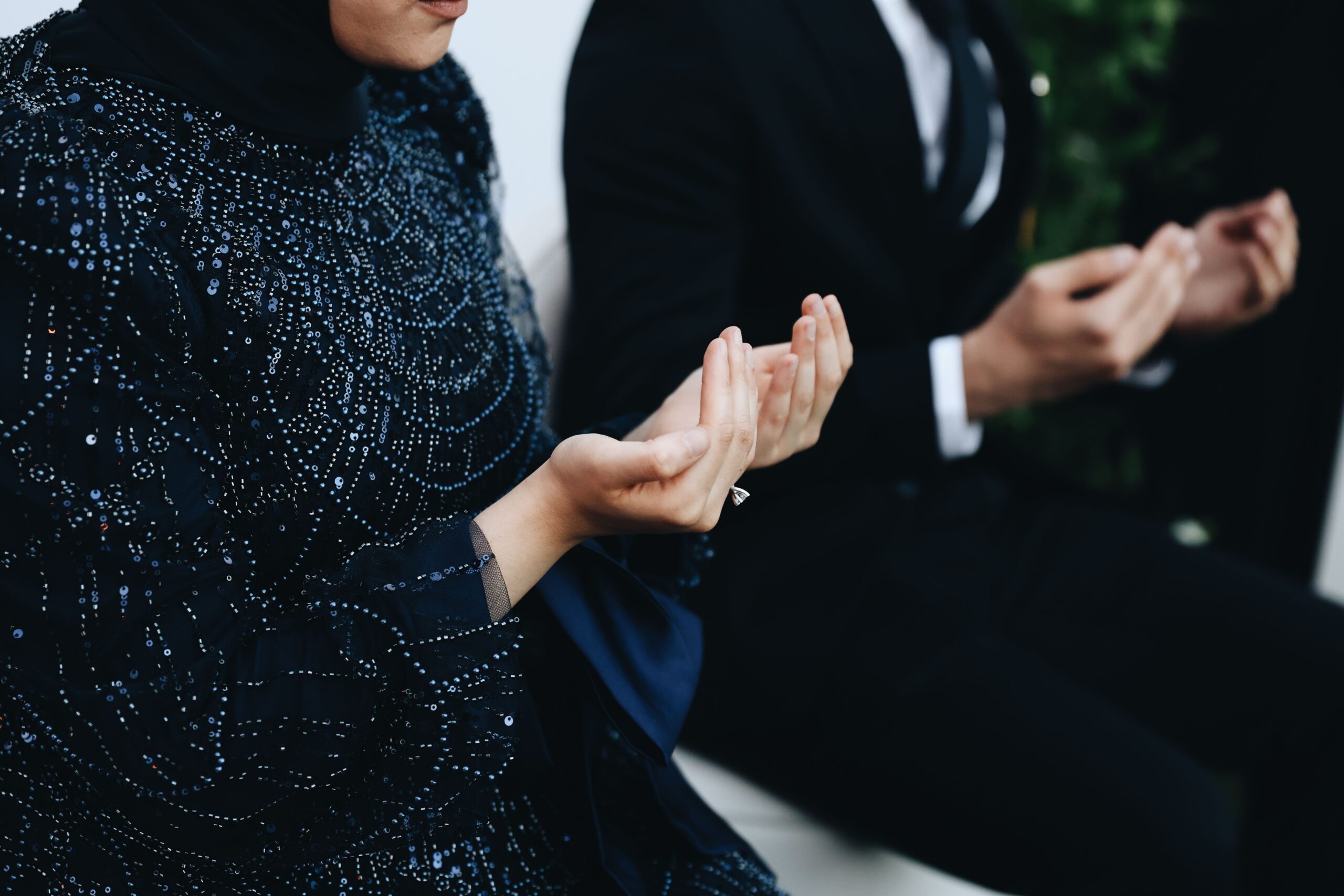 Couple musulman en tenue formale les mains levées en prière lors de la cérémonie de mariage