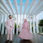 Couple musulman en tenues de mariage traditionnelles sous une pergola blanche élégante
