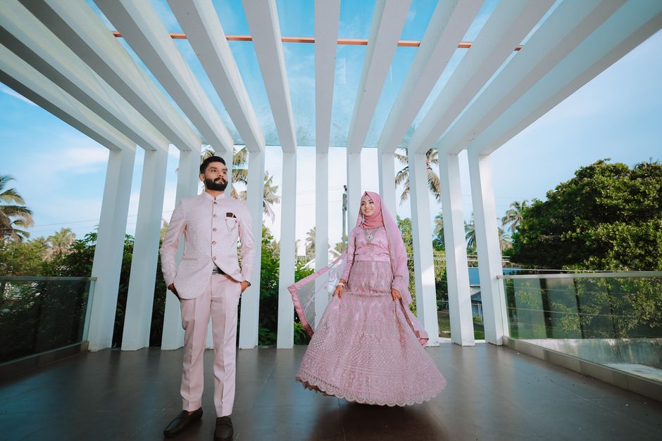 Couple musulman en tenues de mariage traditionnelles sous une pergola blanche élégante