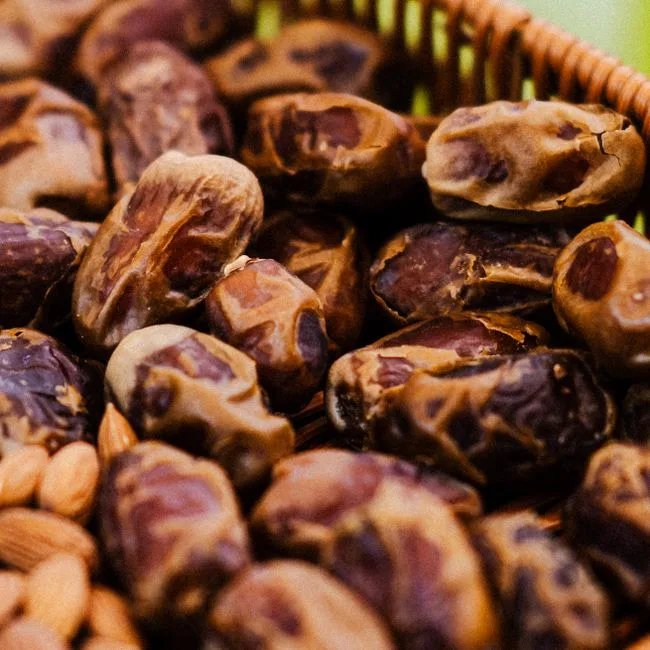 Dattes fraîches et amandes dans un panier en osier