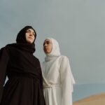 Deux femmes portant des abayas élégantes noir et blanc dans un paysage désertique