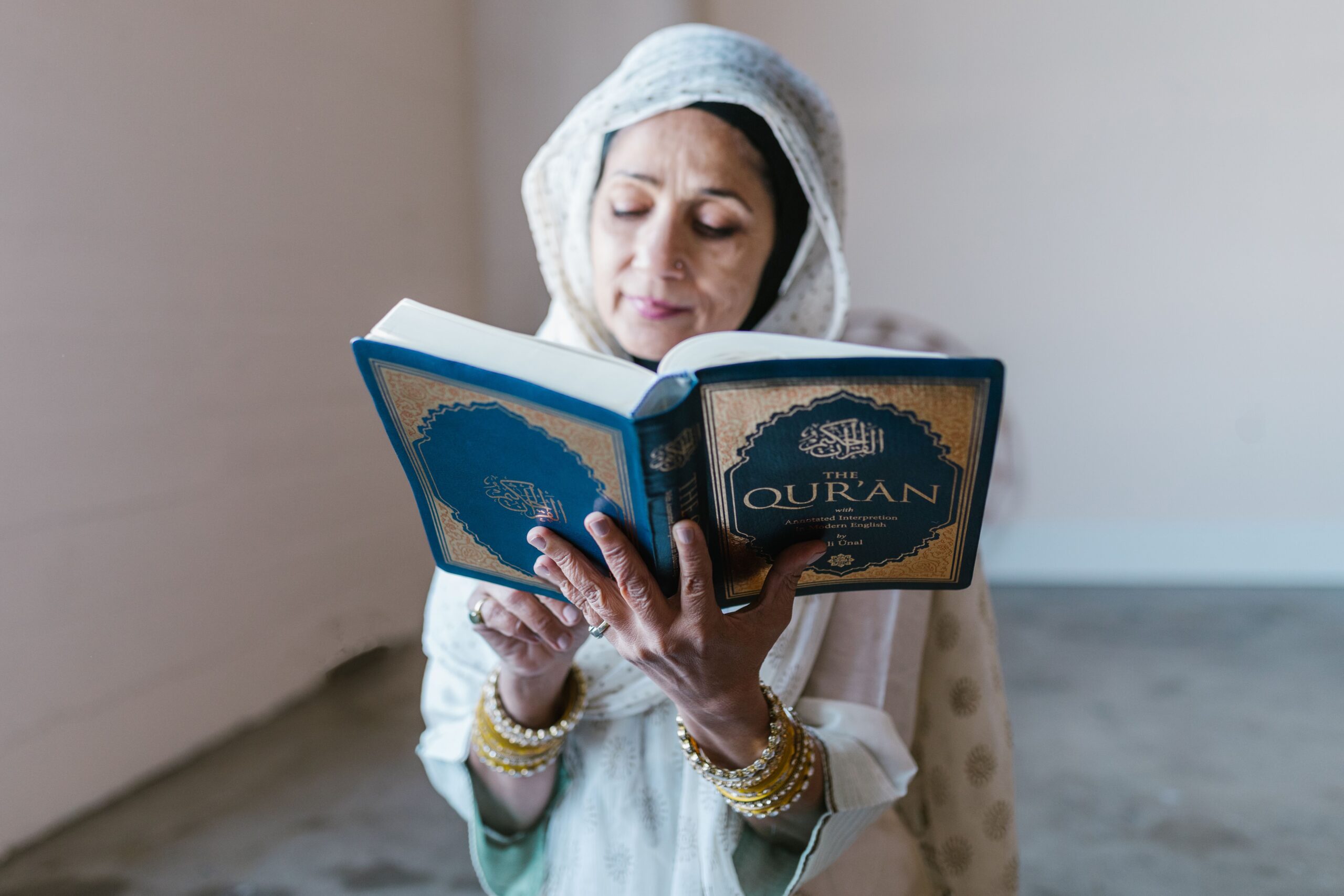 Femme en hijab lisant le Coran avec concentration et dévotion