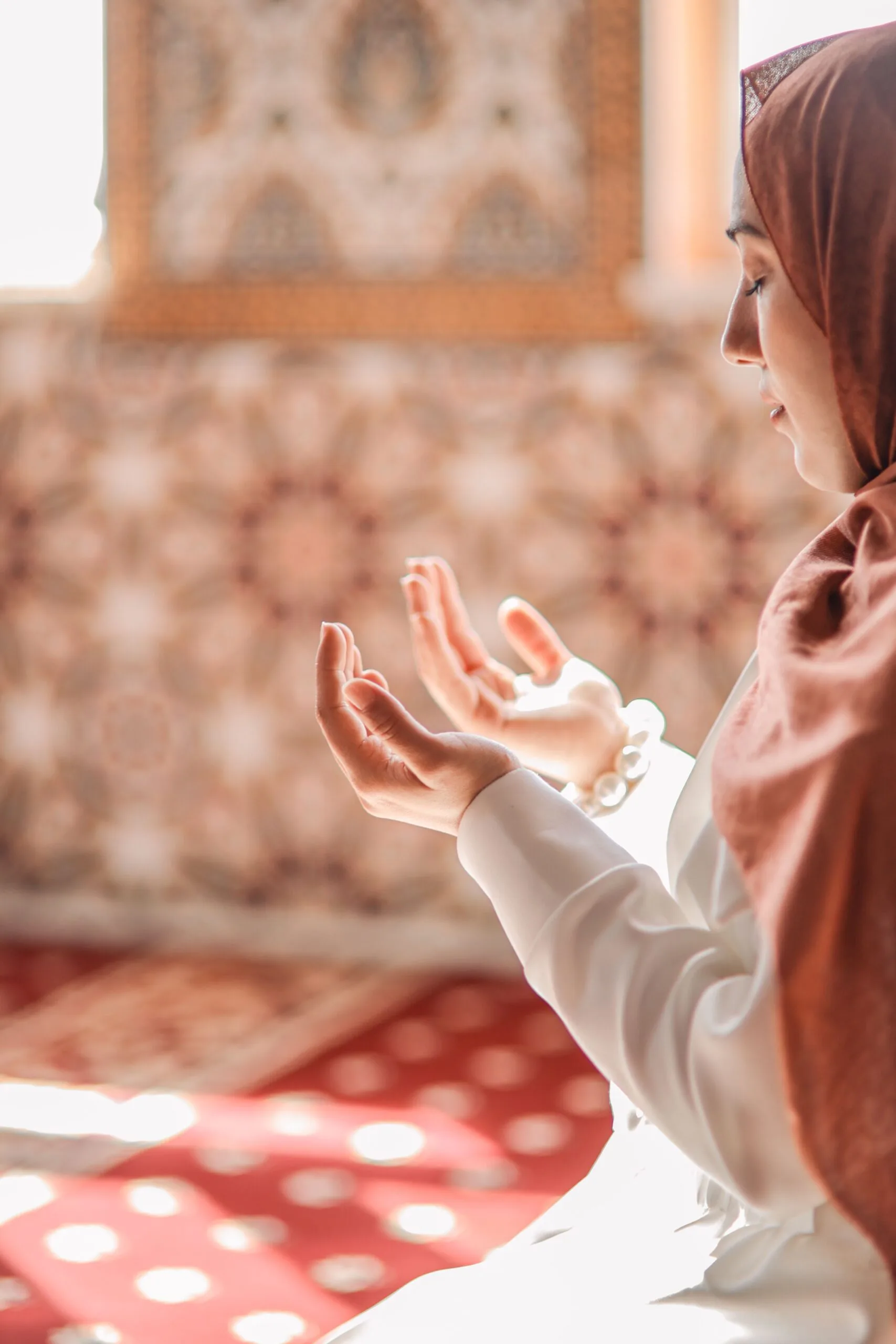 Femme musulmane en prière dans une mosquée baignée de lumière naturelle
