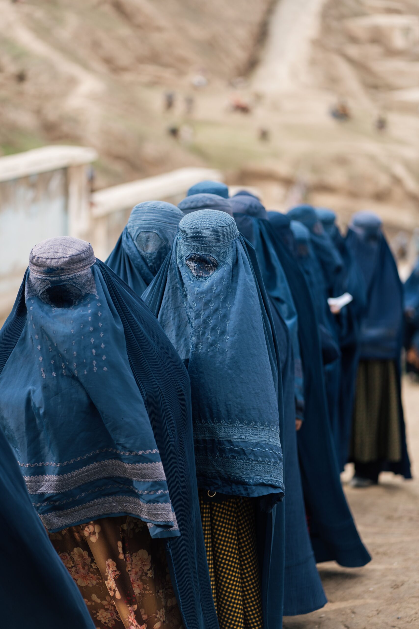 Femmes en burqas bleues marchant dans une région montagneuse d'Afghanistan