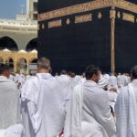 Groupe de pèlerins en vêtements blancs d'ihram rassemblés autour de la Kaaba à La Mecque