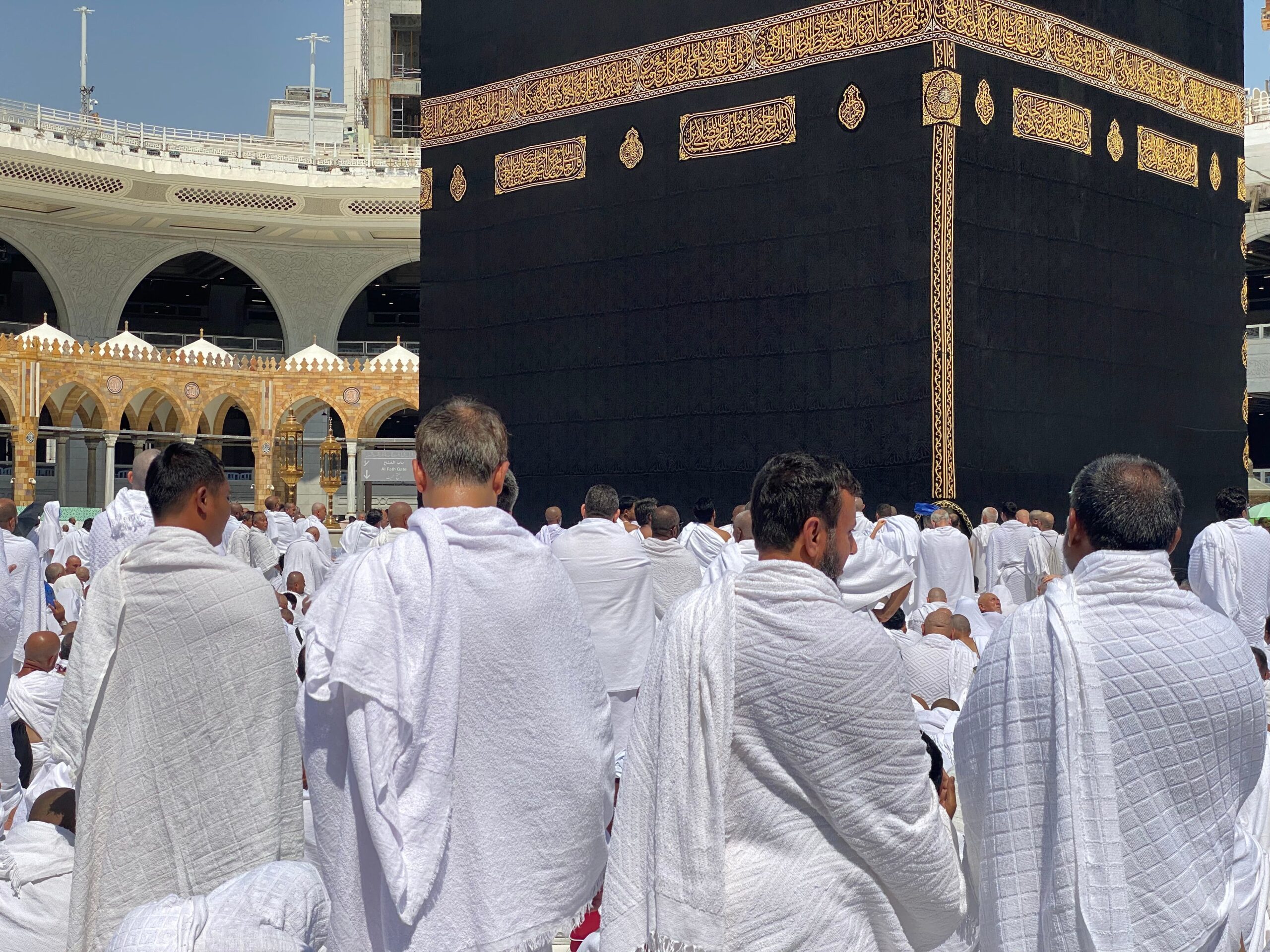 Groupe de pèlerins en vêtements blancs d'ihram rassemblés autour de la Kaaba à La Mecque