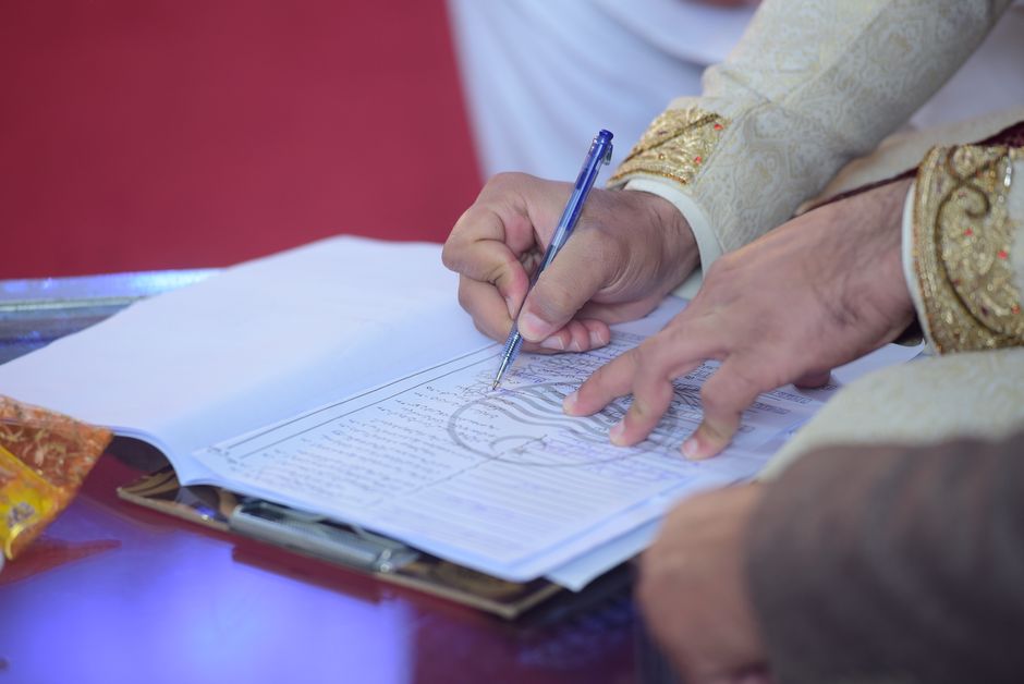 Groom signing the marriage contract during a traditional Islamic ceremony