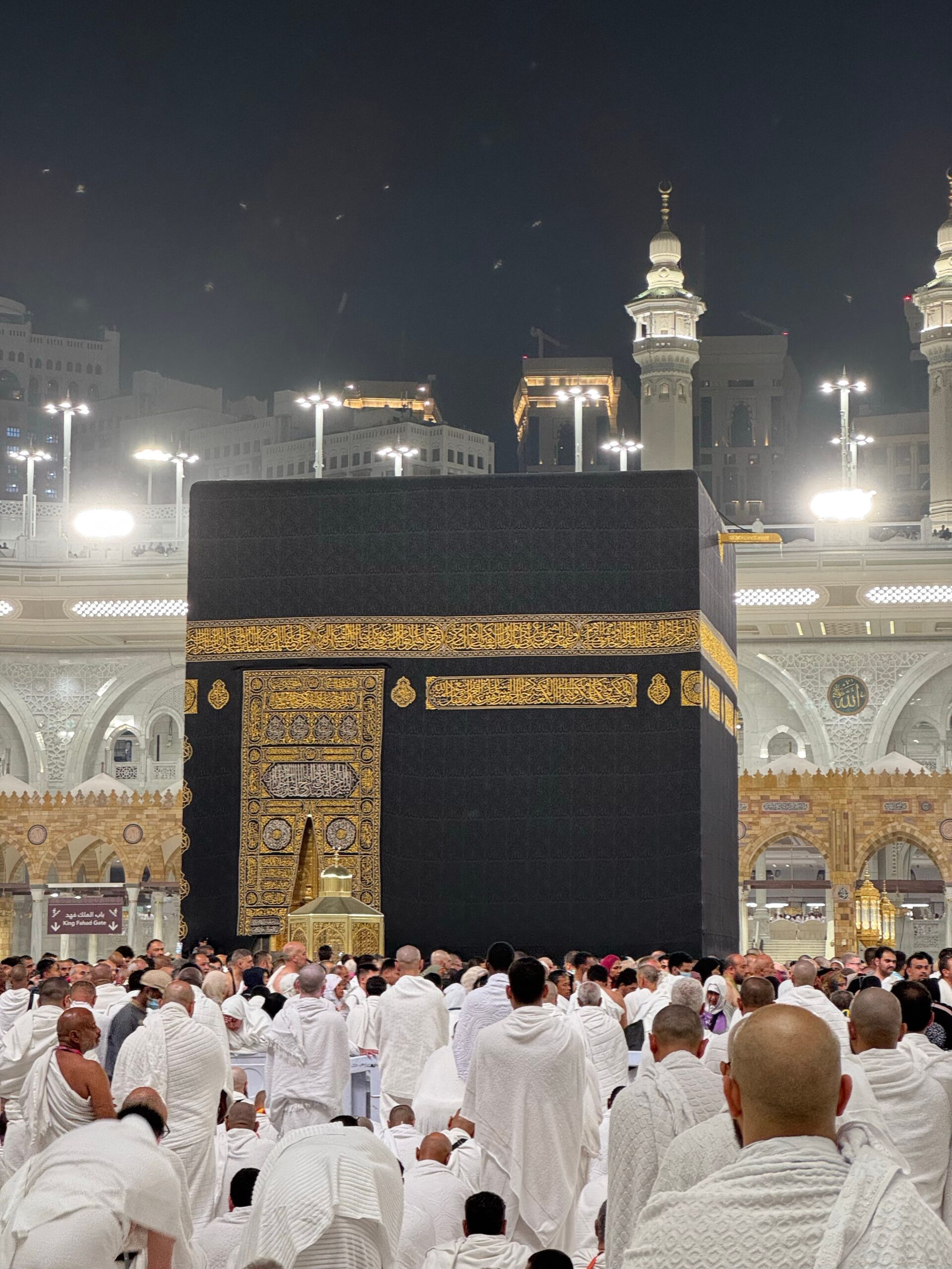 Pèlerins en tenue blanche rassemblés autour de la Kaaba pendant la nuit lors du Hajj