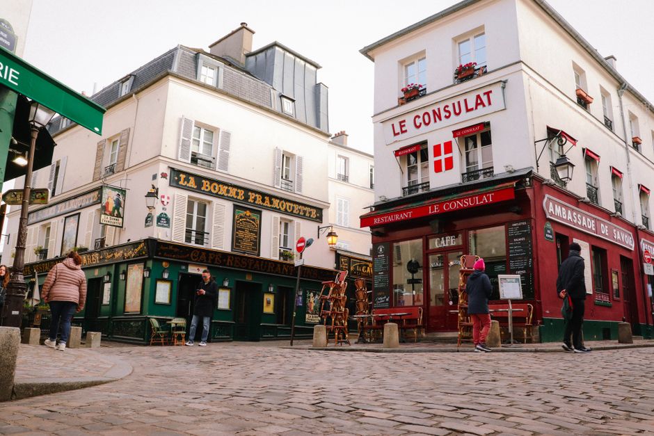 Rue pavée de Montmartre avec restaurants et cafés parisiens typiques aux façades colorées