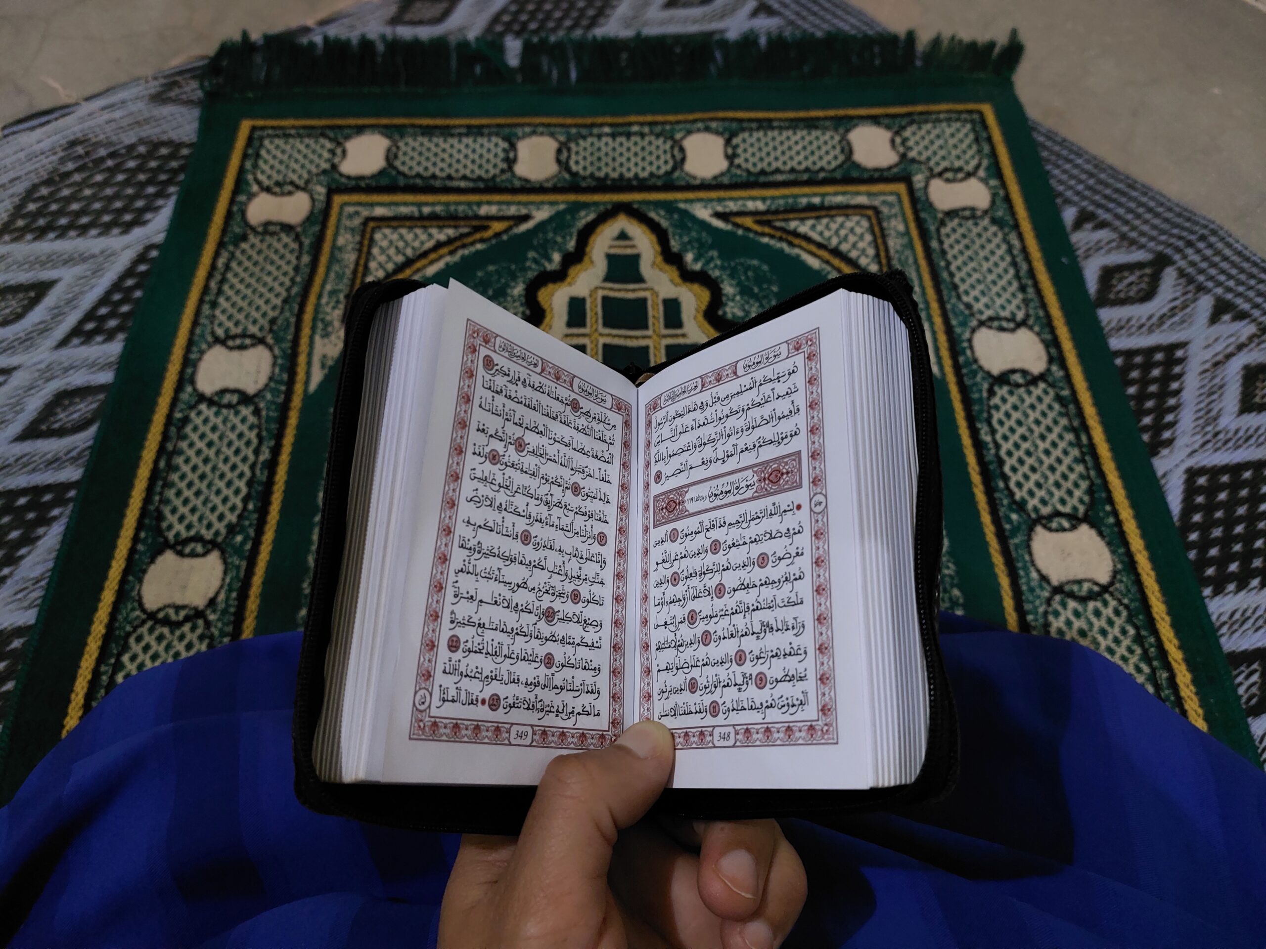 Tapis de prière traditionnel avec Coran ouvert posé dessus