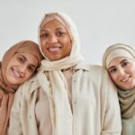 Trois femmes musulmanes portant différents styles de hijab, illustrant la diversité des pratiques