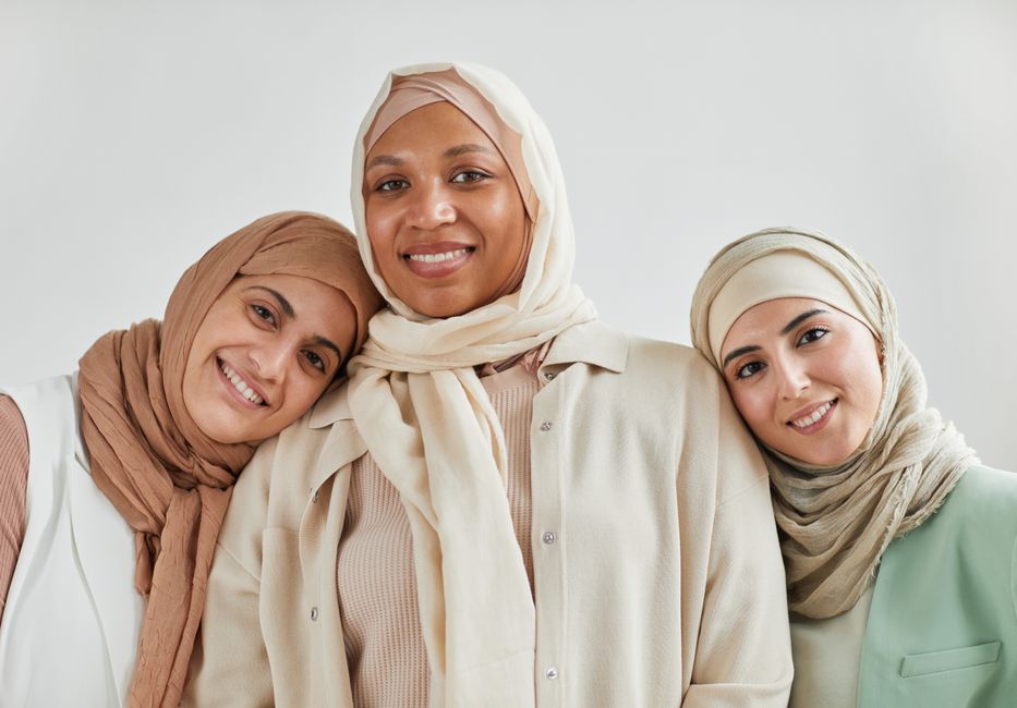 Trois femmes musulmanes portant différents styles de hijab, illustrant la diversité des pratiques